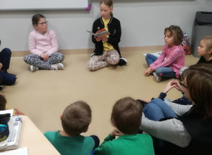 Wolontariusze biblioteczni czytają dzieciom